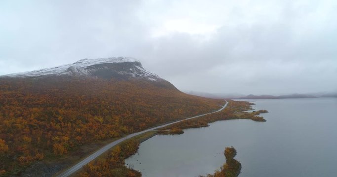 Saanatunturi, Aerial, rising, drone shot, overlooking the saana fell, the Kilpisjarvi lake and e8 road, on a foggy, autumn morning, in Enontekio, Finland