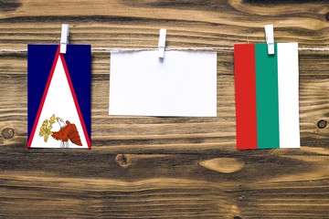 Hanging flags of American Samoa and Bulgaria attached to rope with clothes pins with copy space on...
