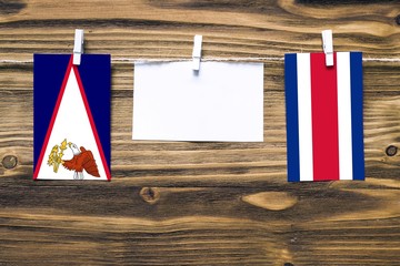 Hanging flags of American Samoa and Costa Rica attached to rope with clothes pins with copy space...