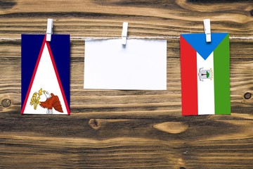 Hanging flags of American Samoa and Equatorial Guinea attached to rope with clothes pins with copy...