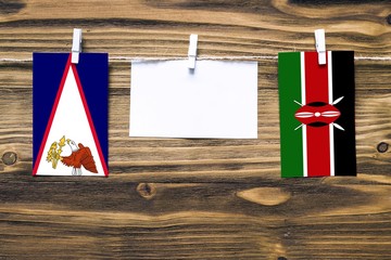 Hanging flags of American Samoa and Kenya attached to rope with clothes pins with copy space on...