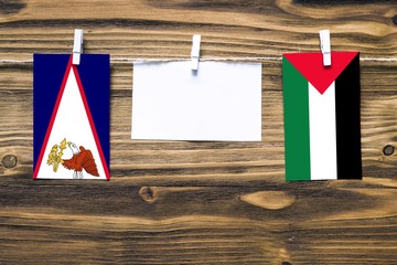 Hanging flags of American Samoa and Palestine attached to rope with clothes pins with copy space on...