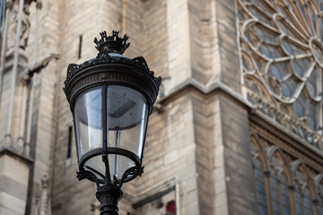 Vintage street lamp with gothic church in background