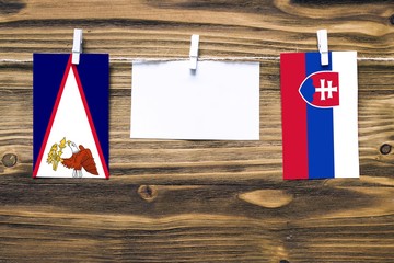 Hanging flags of American Samoa and Slovakia attached to rope with clothes pins with copy space on...