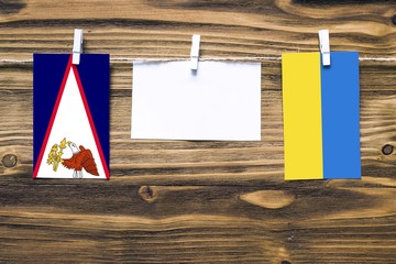 Hanging flags of American Samoa and Ukraine attached to rope with clothes pins with copy space on...
