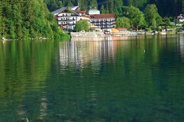 Obraz premium Reflection of hotel and trees on View of Lake Eibsee in Bavaria, Germany.