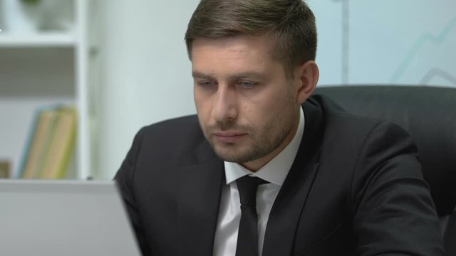Exhausted businessman yawning and sleeping in office during extra hours work