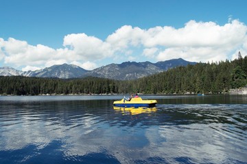 View of Eibsee is a lake in Bavaria, Germany, with people on yellow peddle boat. 