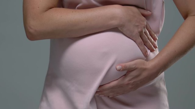 Pregnant woman touching belly, suffering from ache, risk of misbirth, health