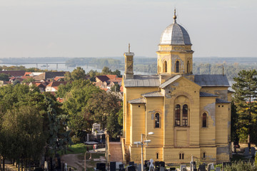 Fototapeta na wymiar Panorama of Zemun from the Gardos Hill with the Zemun cemetery and the Saint Dimitri Church in front (Crkva Svetog Dimitrija) with typical orthodox graves and tombs