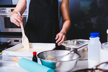 Woman owner bakery shop mold cake flour after batter