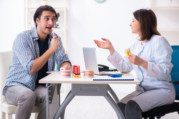 Young man visiting female doctor stomatologist