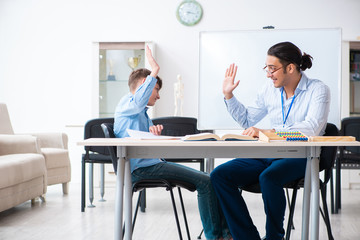 Obraz premium Young father helping his son to prepare for exam