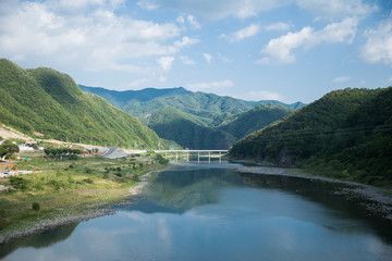a wide river passing through green mountains