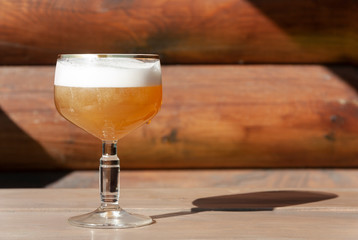 Glass of light beer is on wooden table with copy space