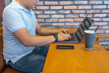 Overweighted male freelancer on laptop at table in cafeteria
