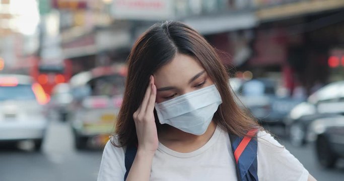 Woman wearing mask and looking to camera at city. Health care and medical concept.