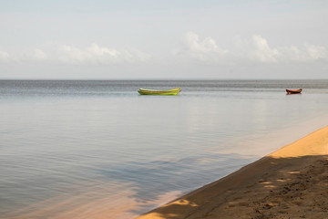 beach with morning sun with boat moored in de rio in amazon.