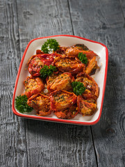 A bowl of freshly cooked sun-dried tomatoes on a wooden table. Vegetarian food.