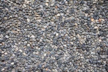 Abstract background texture built of small stones wall.