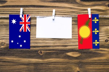 Hanging flags of Australia and Guadeloupe attached to rope with clothes pins with copy space on...