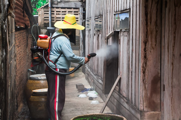 Fototapeta premium A man use a sprinkler ULV type for kill mosquito carrier of Zika virus and dengue fever it outbreak in the rainy season,A man use fumigation machine kill mosquitoes. 
