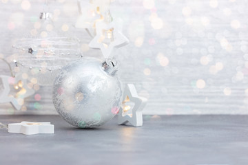 christmas tree decorations – silver glass balls, decorative star lights on white wooden background