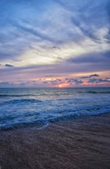 Phuket beach sunset, colorful cloudy twilight sky reflecting on the sand gazing at the Indian Ocean, Thailand, Asia.