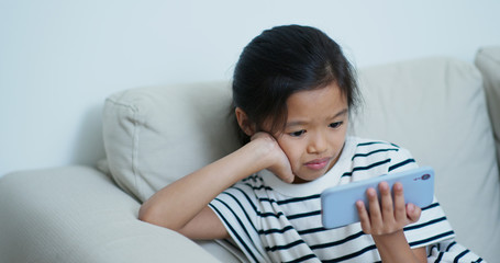 Little girl watch on cellphone at home