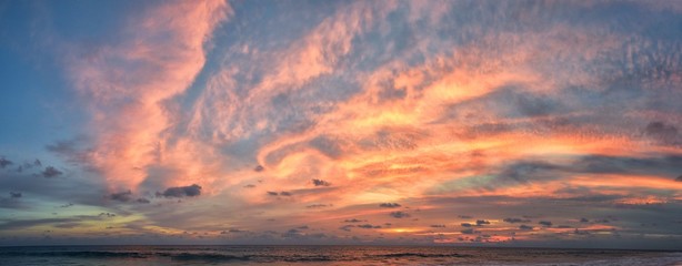 Phuket beach sunset, colorful cloudy twilight sky reflecting on the sand gazing at the Indian Ocean, Thailand, Asia.