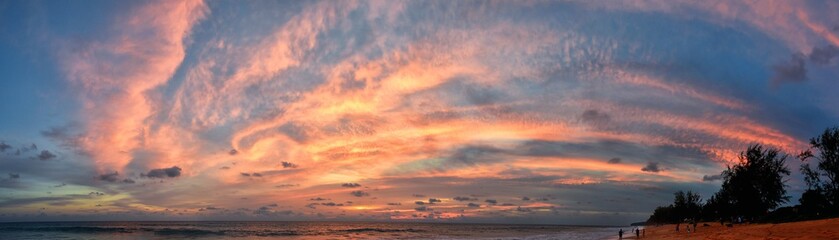 Phuket beach sunset, colorful cloudy twilight sky reflecting on the sand gazing at the Indian Ocean, Thailand, Asia.