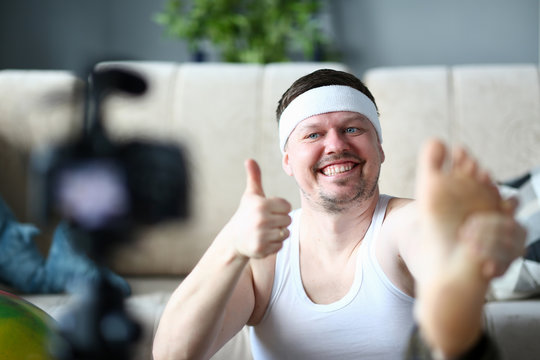 Cheerful Blogger Do Exercise and Hold Thumb Up