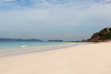 Fototapeta na wymiar Container shipping by the sea. Sand beach tropical summer background. Cargo ship.