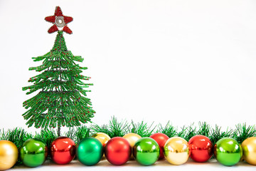 Wire Christmas tree with Christmas decorations and tinsel on a white background  