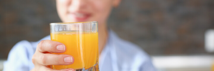 Beautiful woman hold in arms glass of orange juice