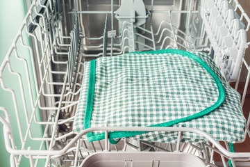 Green apron lies in the dishwasher for washing