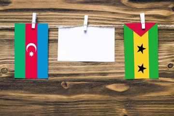 Hanging flags of Azerbaijan and Sao Tome And Principe attached to rope with clothes pins with copy...