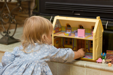little girl playing with children's house