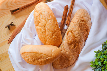 Freshly baked delicious bread on wooden table with white cloth