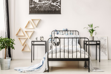 Black map on white wall of fashionable kid's bedroom with industrial single bed and nightstand with...