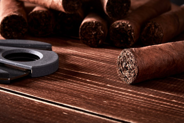 Still life with cuban cigars and cutter on old wooden board table - obrazy, fototapety, plakaty