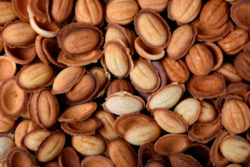 Walnut shaped cookies halves scattered on the oven tray. Food background