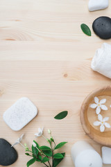 Flat lay Spa composition with body care items on wood background. Sea salt in bowl, towels, scrub, aroma oil in bottles and flowers.