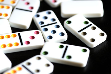 White domino scattered on a black background close-up