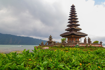 Fototapeta na wymiar Beautiful Balinese Ulun Danau temple on lake Beratan in cloudly day in extinct volcano crater in Bali, Indonesia.
