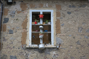 window decorated with old enemal pans and pots with plants