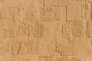 Fototapeta na wymiar Ancient egyptian paintings and hieroglyphs on a wall in Mortuary temple of Hatshepsut in Luxor, Egypt