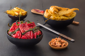 Fermented products red and green hot peppers on a black table - traditional Korean food. Copy space