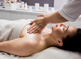 Obraz na płótnie Canvas Beautiful young woman enjoying massage in spa salon. Cosmetology