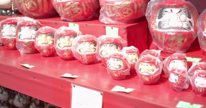 Darumo dolls lined up at a market in Kyoto, Japan soft lighting